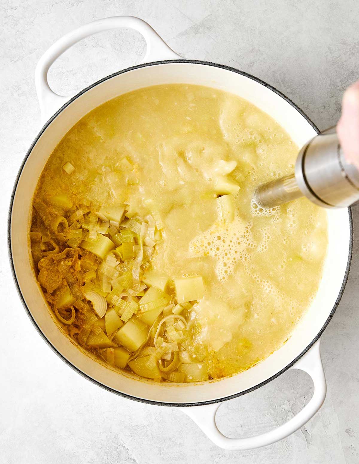 Blending potato leek soup with immersion blender.
