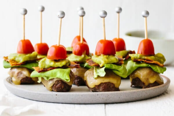 Guacamole bacon burger bites on a plate next to a napkin