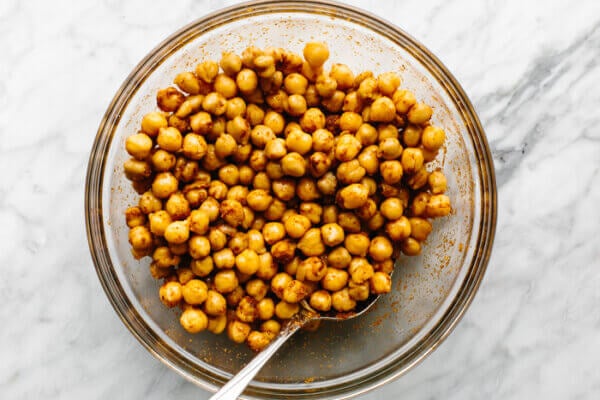 Chickpeas tossed in spices in a bowl for roasted chickpeas