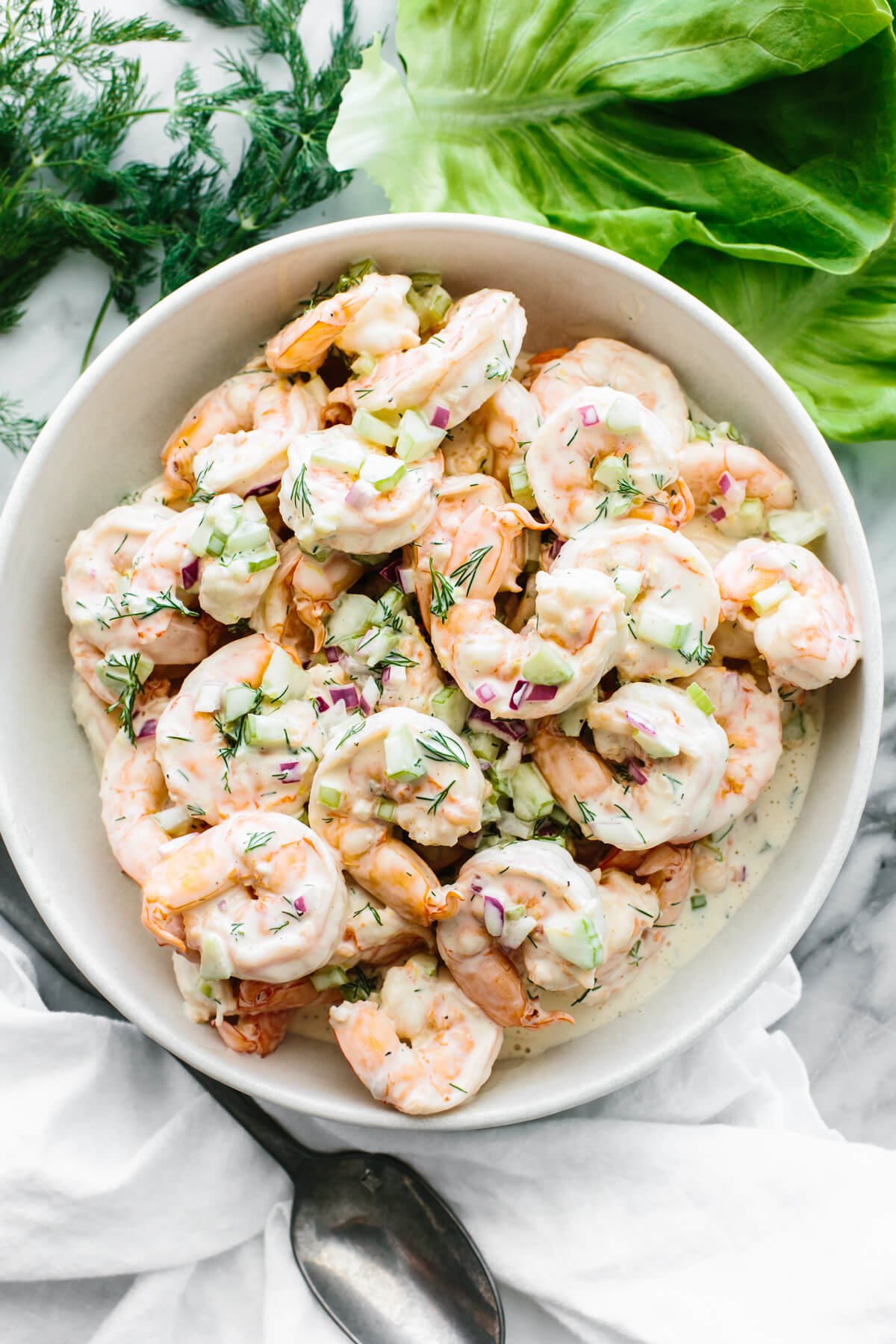 This is a shrimp salad recipe you'll want to eat all summer long! It's ultra-refreshing, deliciously creamy, and oh so easy to make. Shrimp salad in a large white bowl