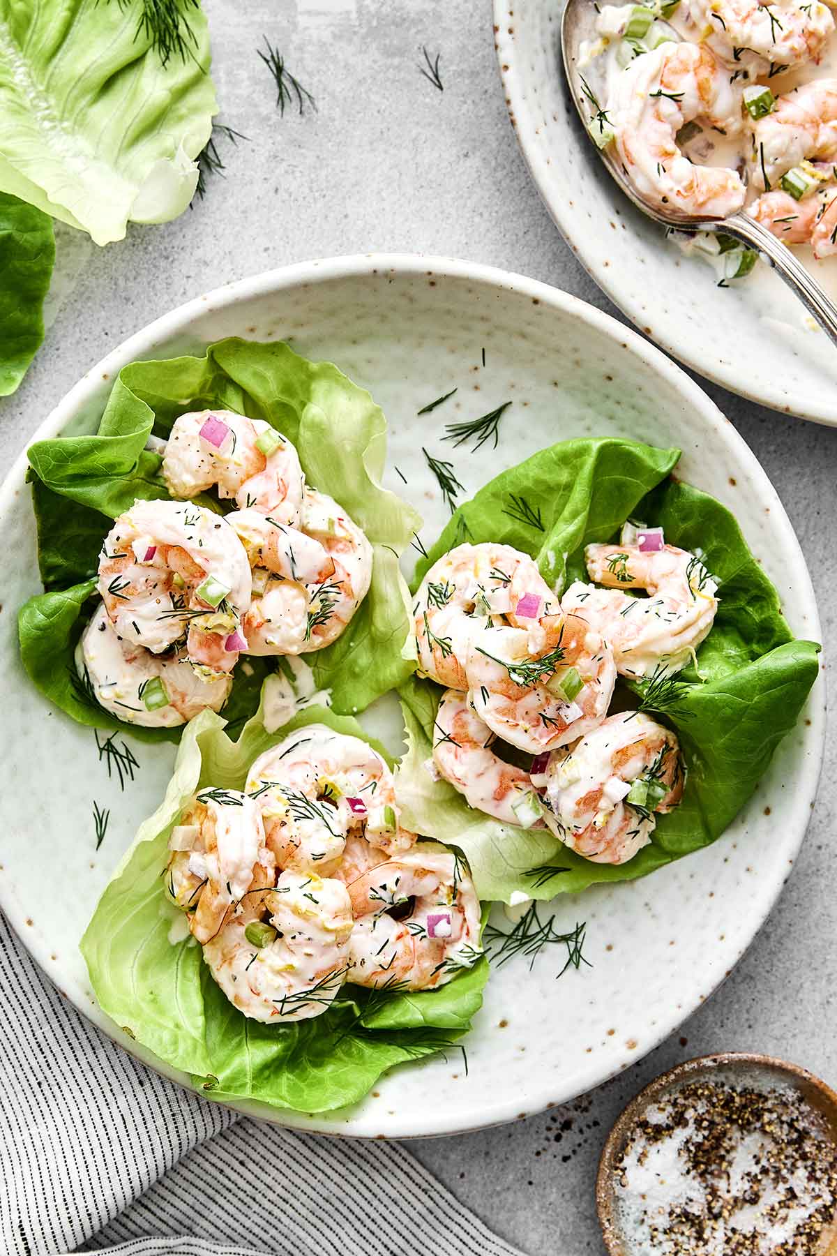 This cold shrimp salad is the ultimate summer salad! Chilled shrimp are tossed with crisp celery and red onion, then coated in a bright, creamy dressing. Shrimp salad on lettuce leaves.