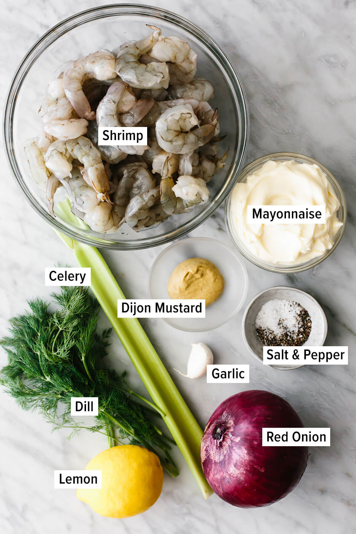 This is a shrimp salad recipe you'll want to eat all summer long! It's ultra-refreshing, deliciously creamy, and oh so easy to make. Ingredients for a shrimp salad on a table