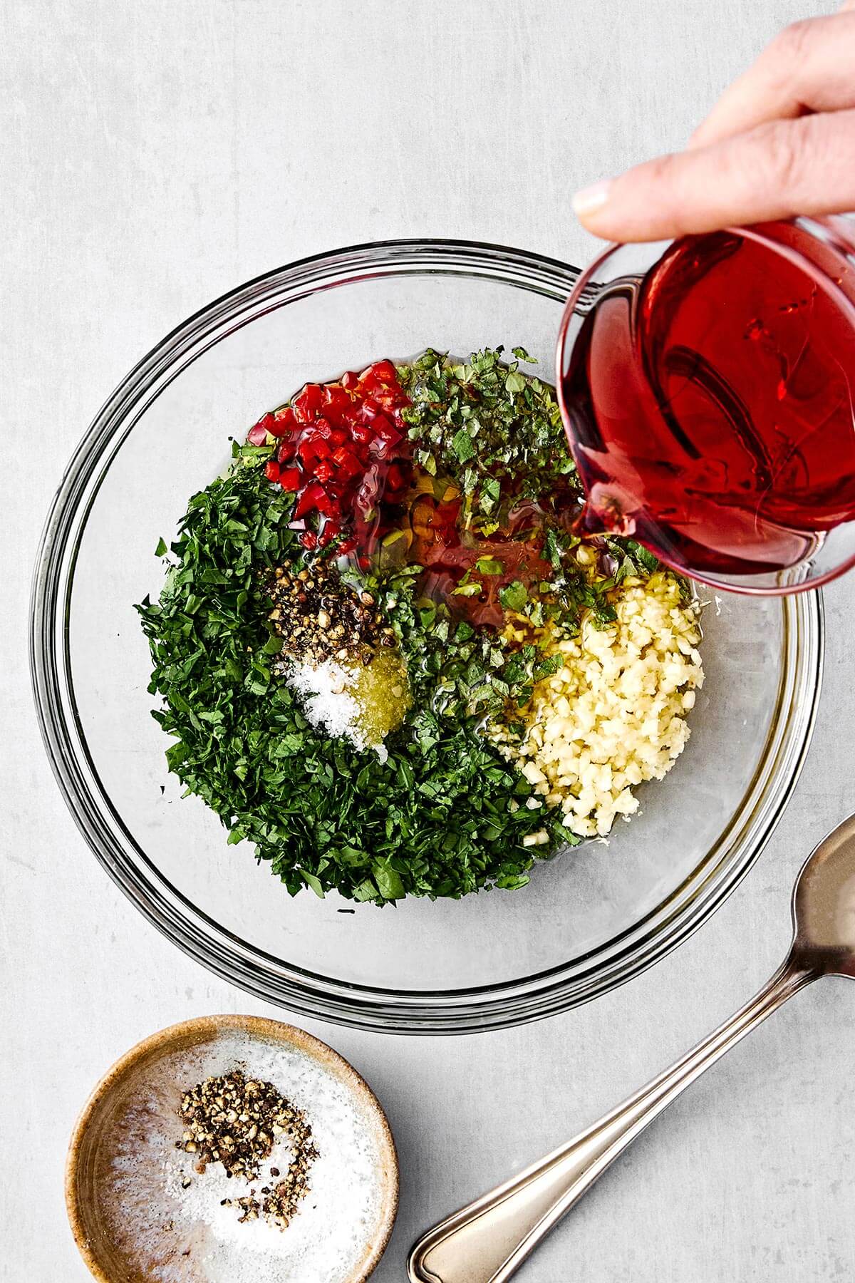 The perfect sauce for grilled meats, vegetables, and more! This chimichurri sauce is packed with herbs and fresh, tangy flavors. Chimichurri sauce ingredients in a bowl.