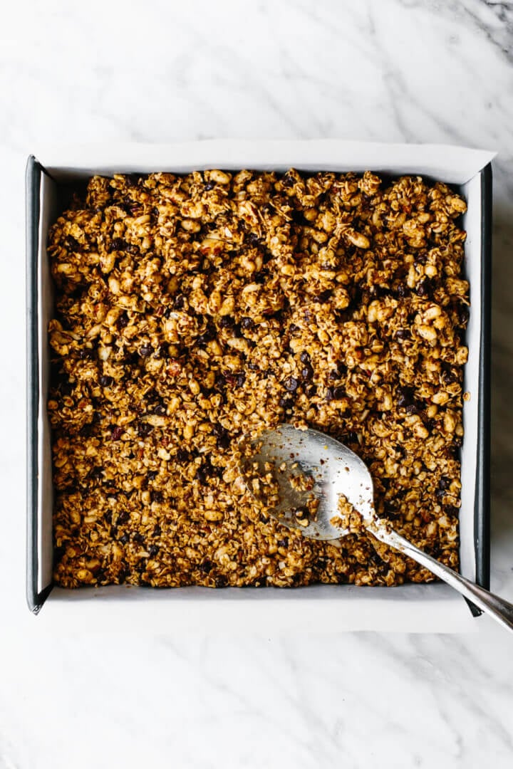 Granola bar mixture in a pan with a spoon