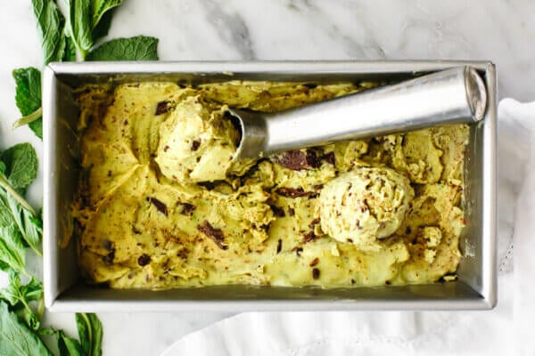Scooping mint chocolate chip nice cream out of a container