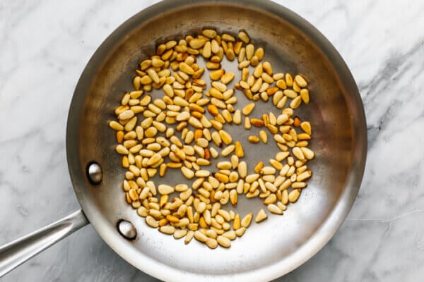 Pine nuts in a pan for roasted radish salad