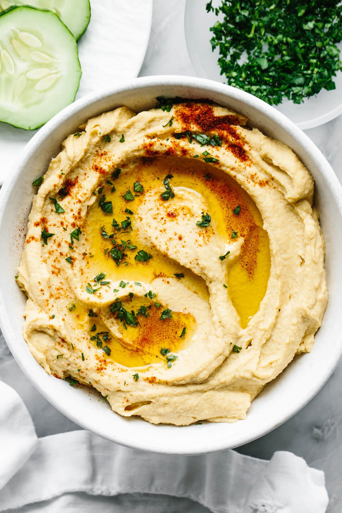 This really is the best hummus recipe! It’s a classic hummus that's creamy, savory, done in under 3 minutes with a blender. A bowl of homemade hummus next to a napkin