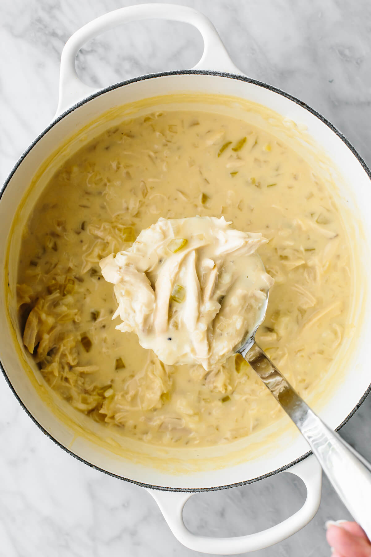 If you love a good chicken and rice combo, this Greek Avgolemono soup is the most comforting, delicious, and easy way to make it! Avgolemono soup in a big white pot with a ladle