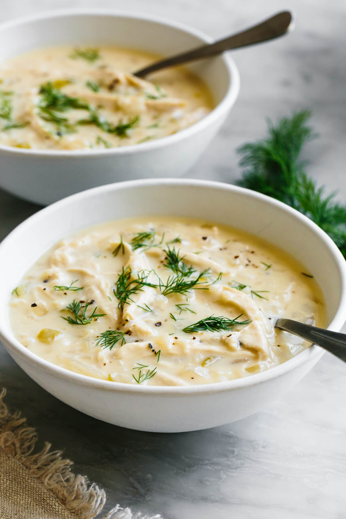 If you love a good chicken and rice combo, this Greek Avgolemono soup is the most comforting, delicious, and easy way to make it! Two bowls of Avgolemono Soup