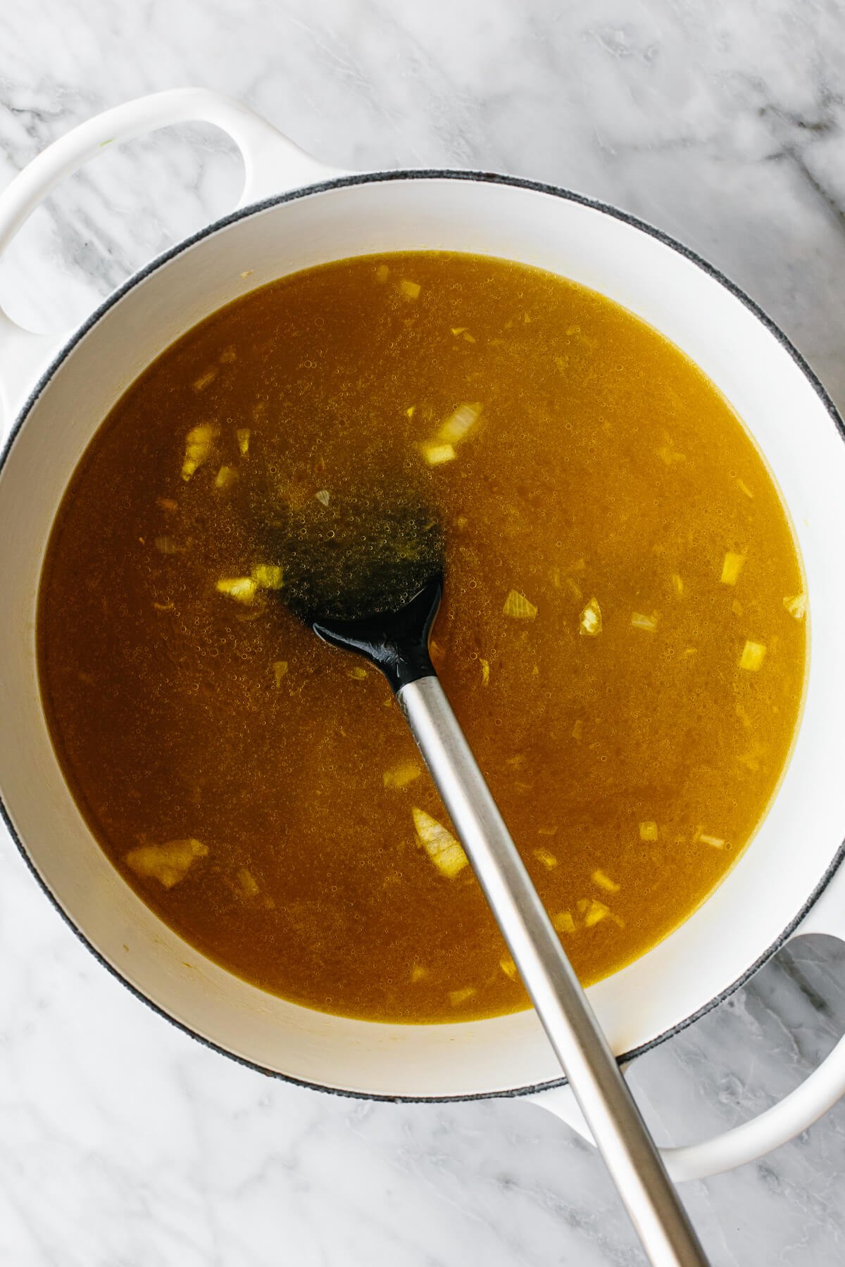 If you love a good chicken and rice combo, this Greek Avgolemono soup is the most comforting, delicious, and easy way to make it! Pouring broth into a pot for Avgolemono soup