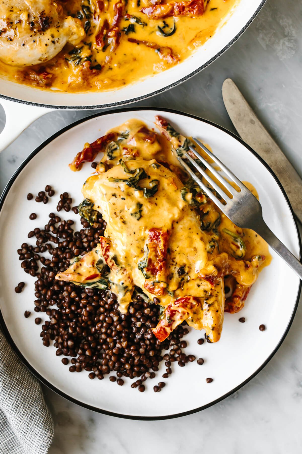 Steal hearts with this creamy tuscan chicken recipe! Seared Italian chicken simmers in a rich and creamy, spinach and sun-dried tomato sauce. A plate of lentils and tuscan chicken