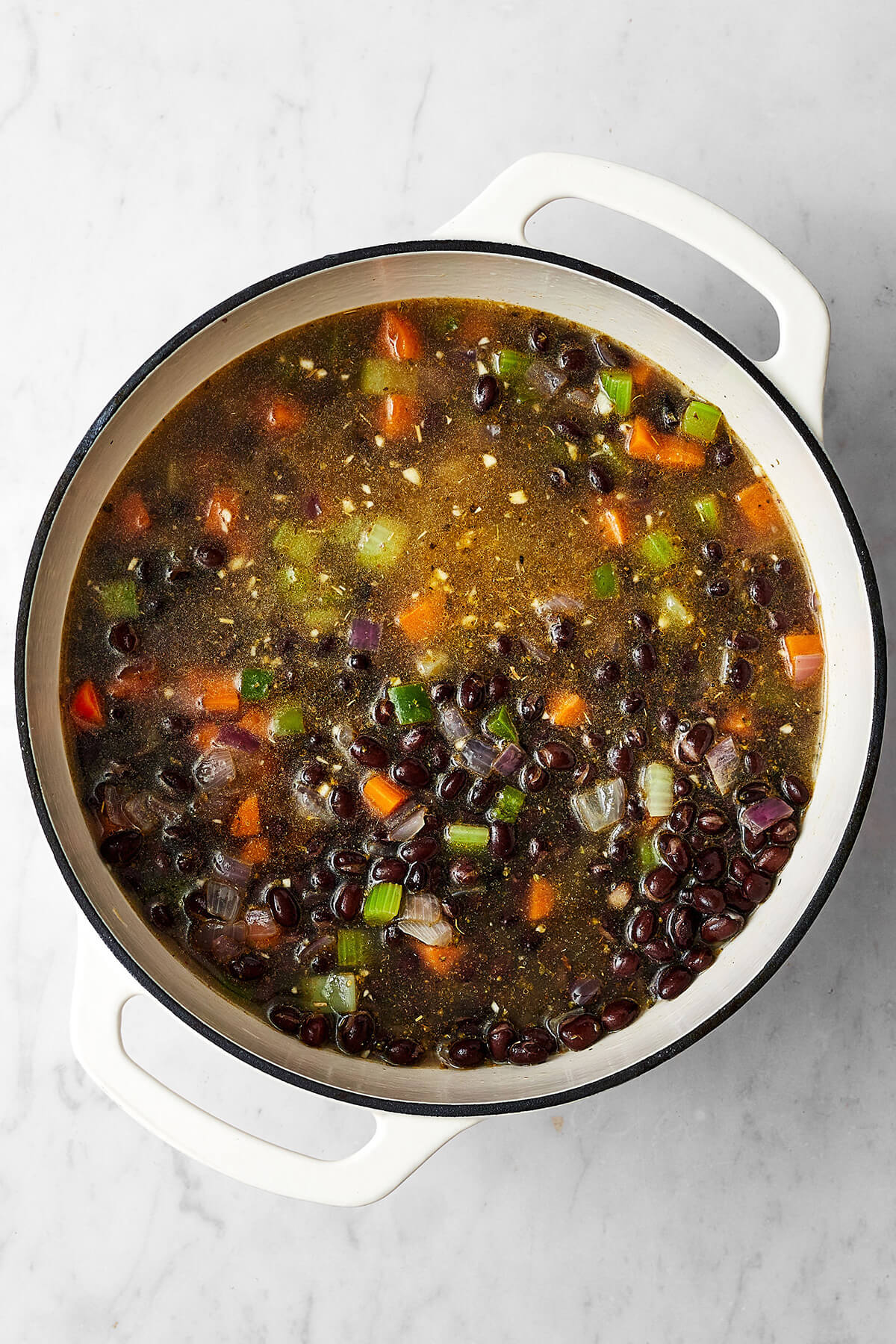 Don't look past this easy black bean soup recipe! It's a delicious vegetarian meal that's filling and layered with savory and spiced flavors. Cooking beans and veggies in a pot for black bean soup