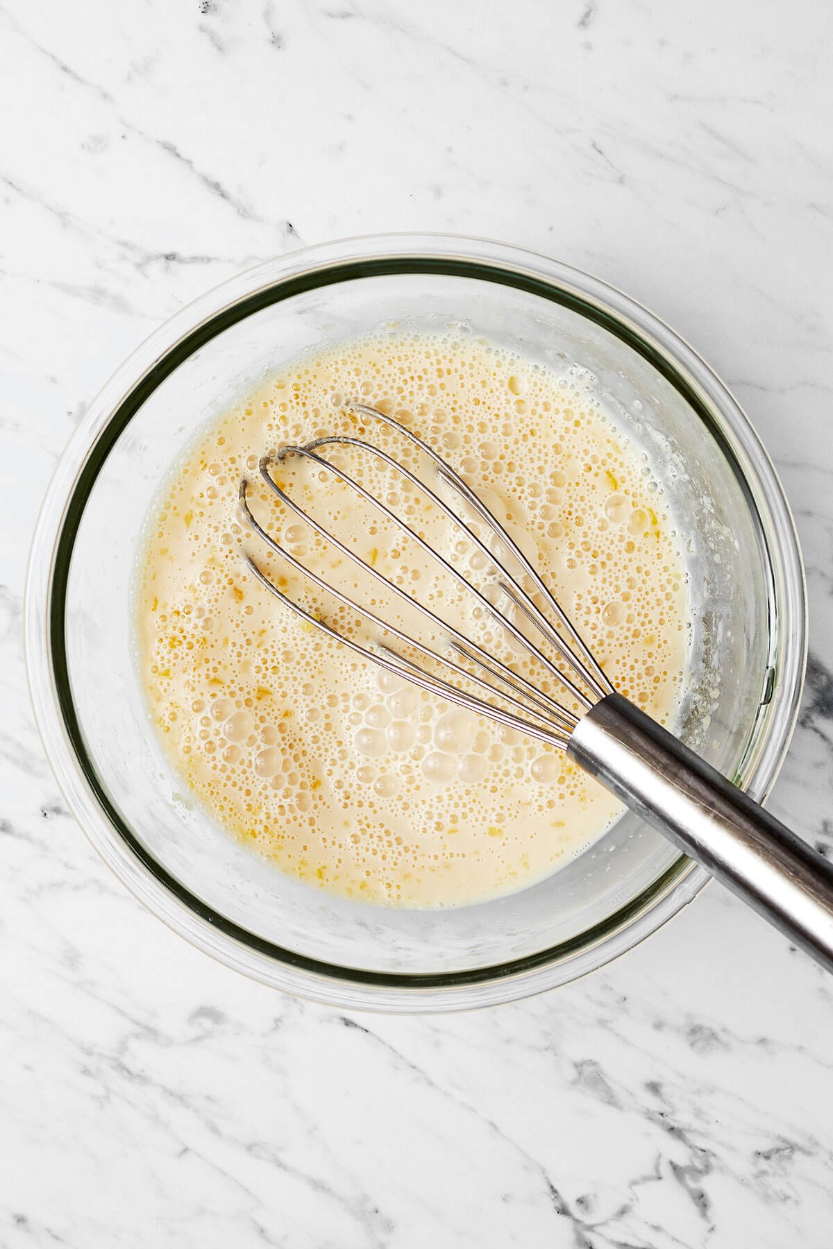 Stirring wet ingredients in a bowl for berry baked oatmeal