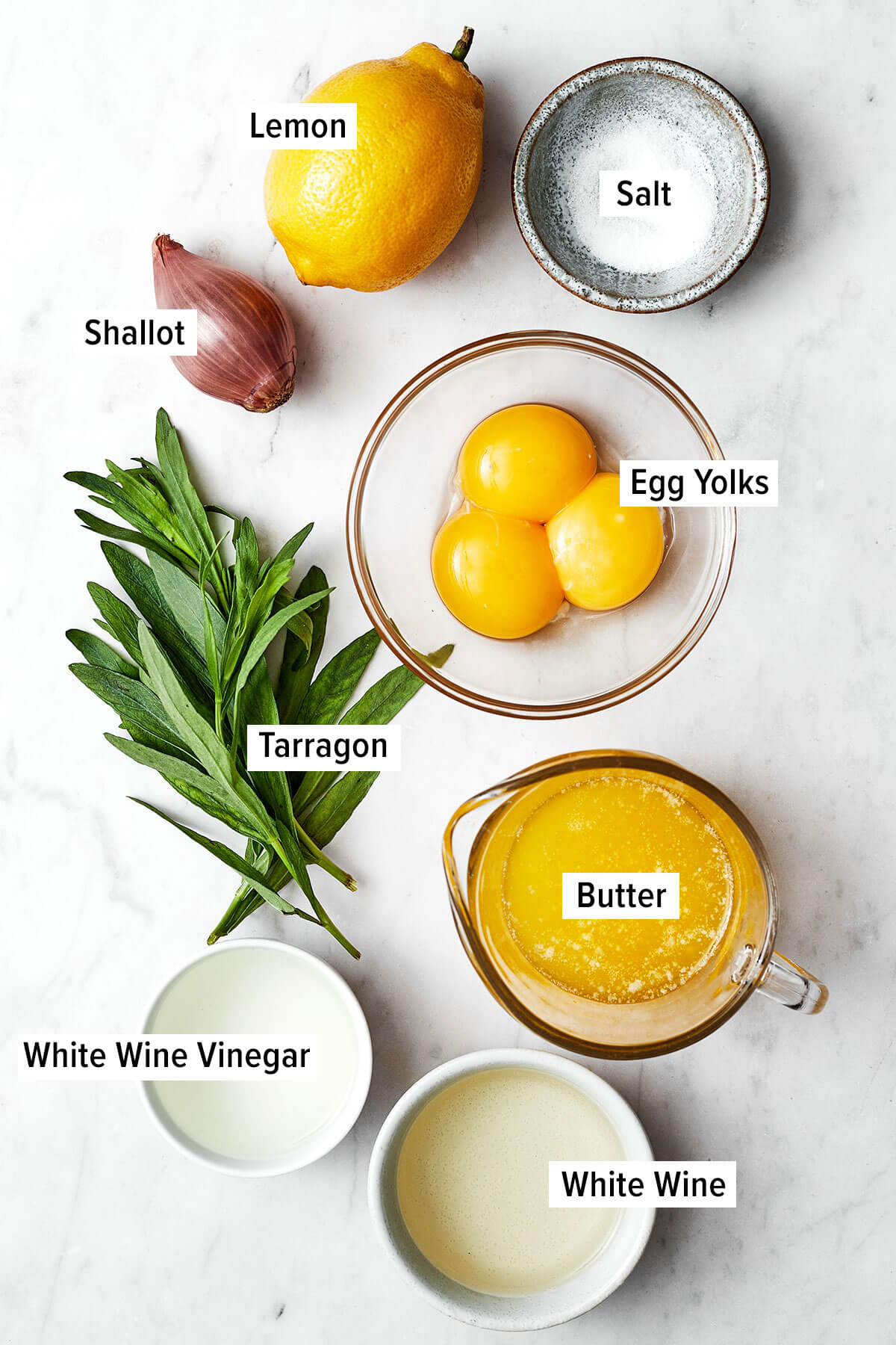A drizzle of this easy béarnaise sauce will instantly elevate any dish! It has a luxurious butter wine base with hints of fresh tarragon. Ingredients for bearnaise sauce on a table