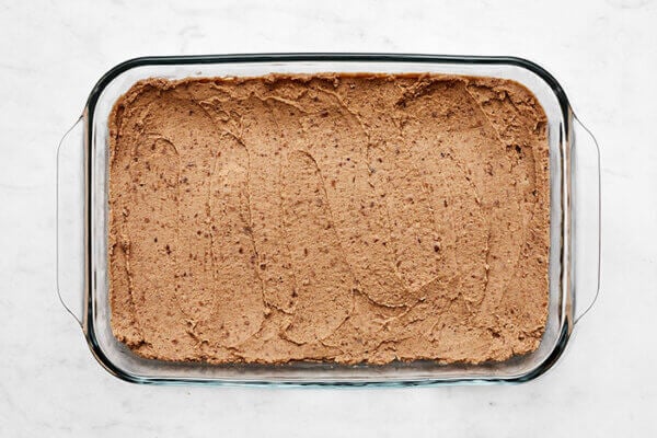 Refried beans in a baking dish for 7 layer dip