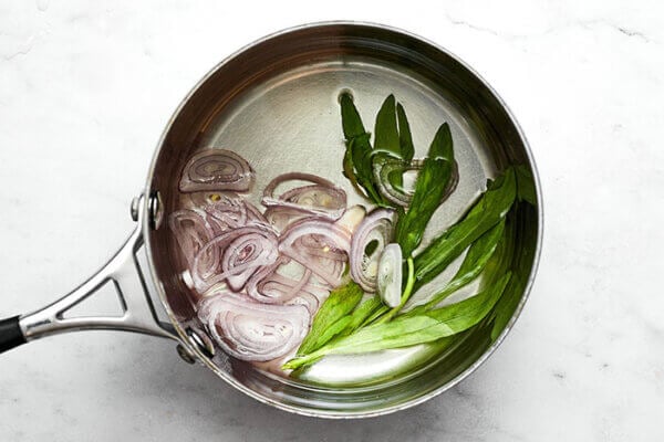 Infused vinegar in a pot for bearnaise sauce