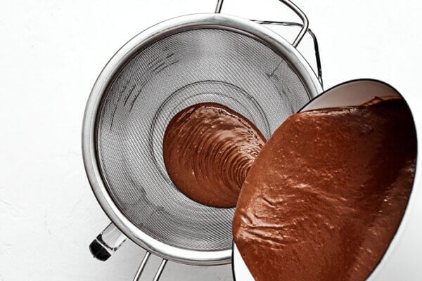 Pouring chocolate through strainer for chocolate pots de creme