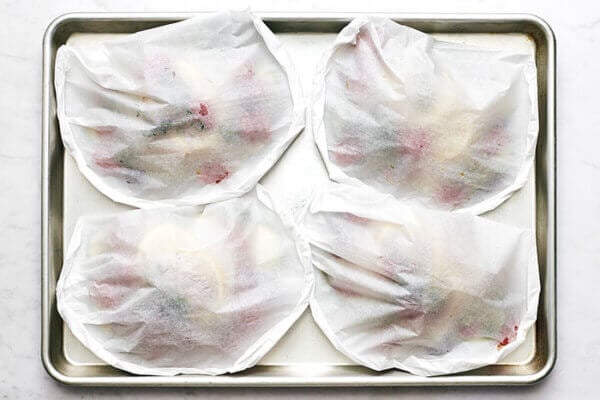 A baking sheet of fish en papillote