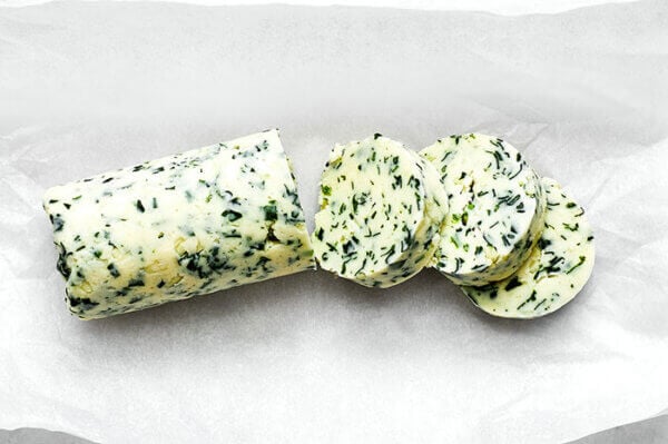 Slices of herb compound butter on a table