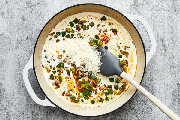 Cooking cajun chicken sauce in a white pan