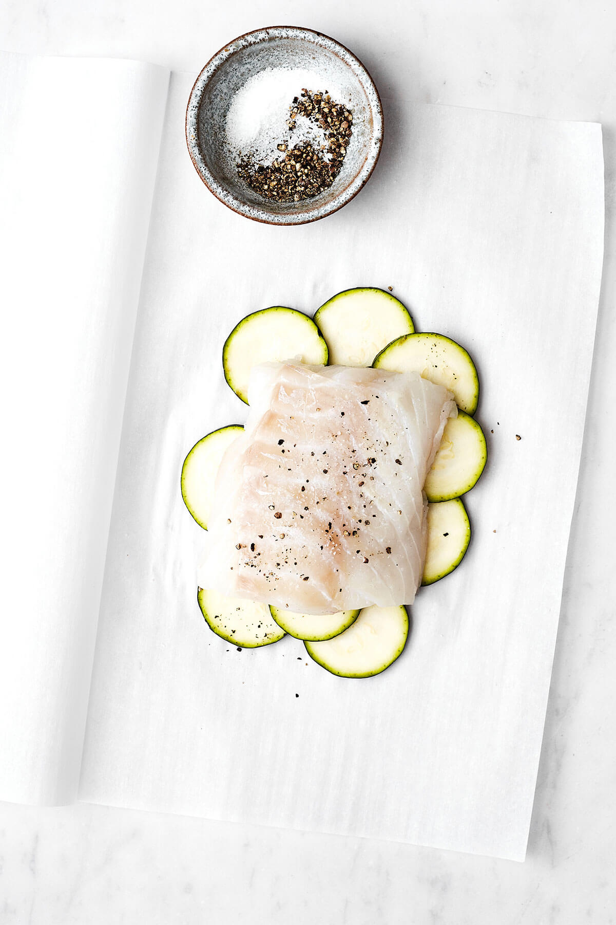 This Mediterranean cod en papillote is the most genius way to quickly achieve a simple, healthy, and super delicious dinner! Initial layers for cod en papillote