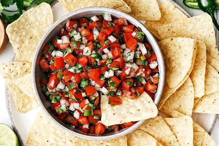 A bowl of pico de gallo and tortilla chips.