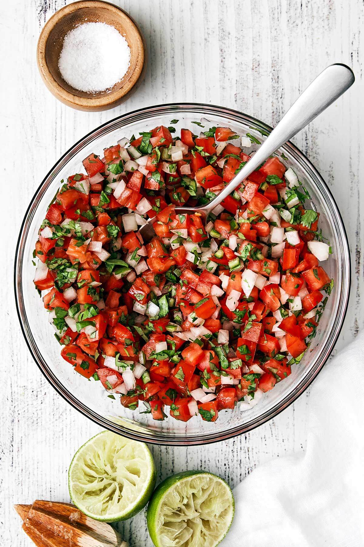 Mixing pico de gallo in a bowl.