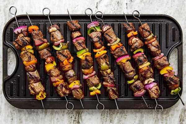 A grill with beef shish kabobs