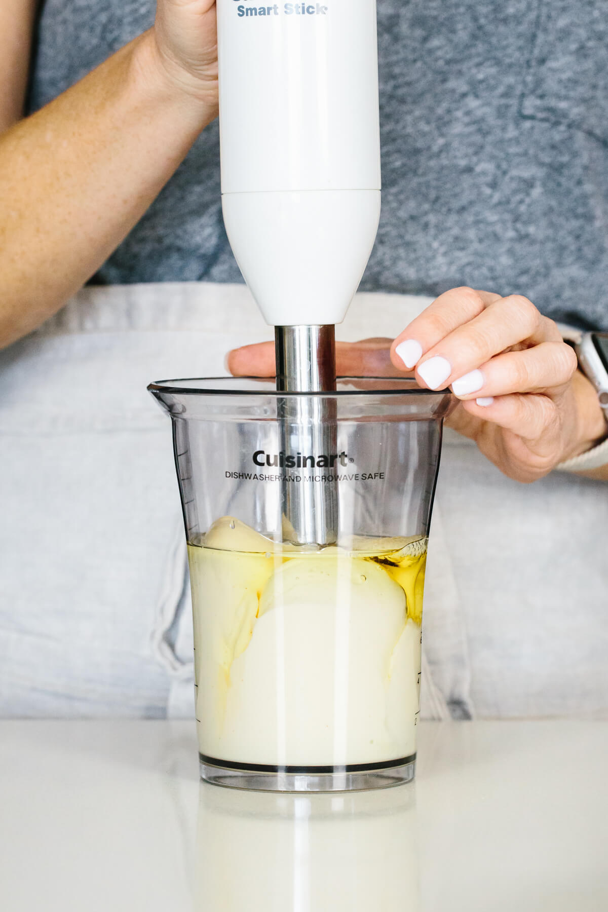 Blending mayonnaise with a stick blender.