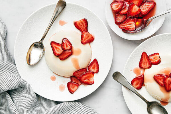 Plates of panna cotta with strawberries