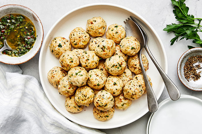 A plate of chicken meatballs with a fork