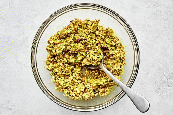 Mixing a pistachio topping in a bowl
