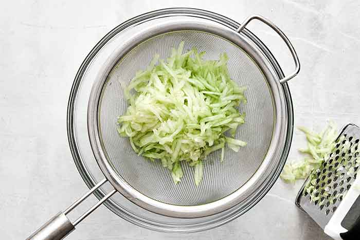 Step one of tzatziki sauce: grate the cucumber.
