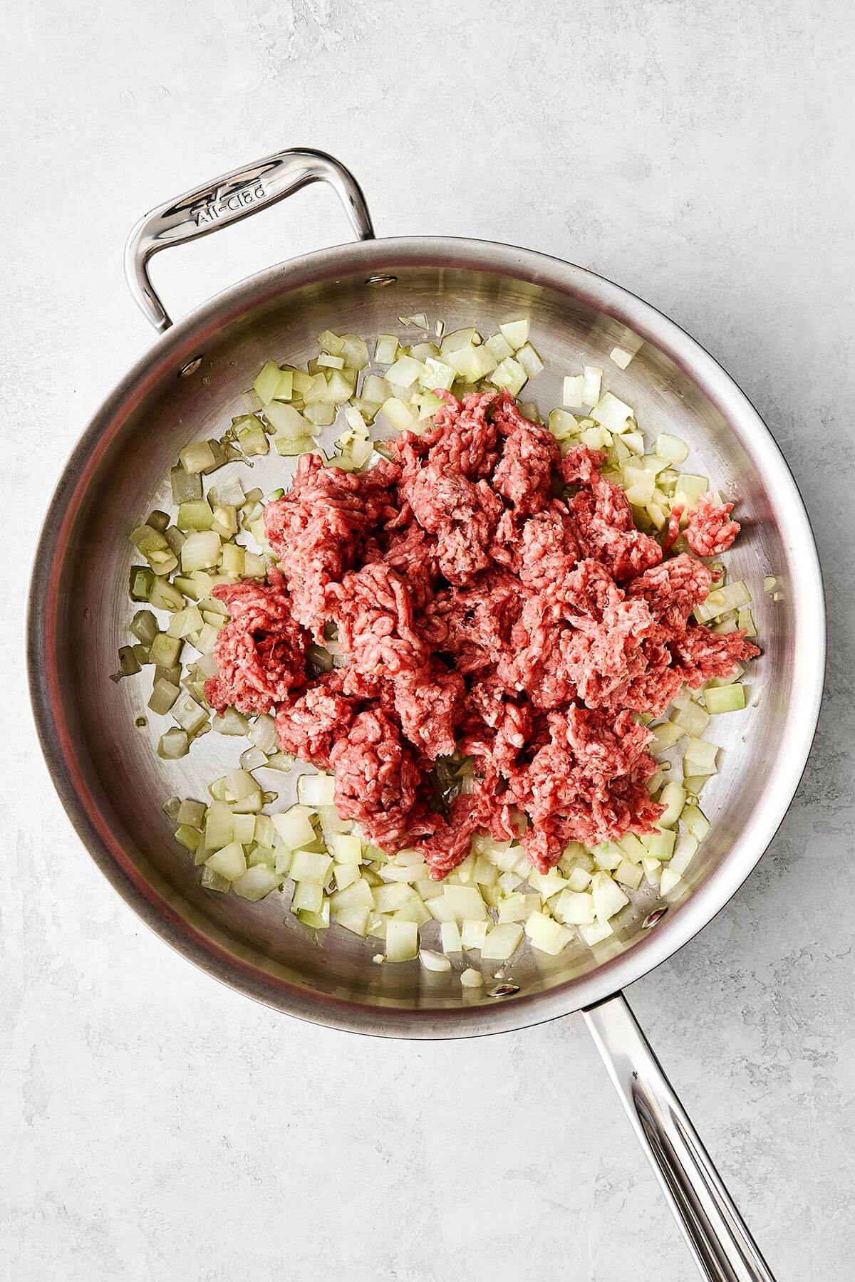 Cooking ground beef and onion in a pan.