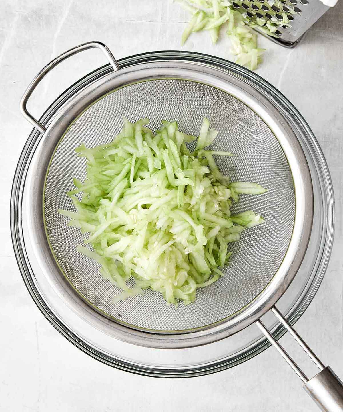 Step one of tzatziki sauce: grate the cucumber.