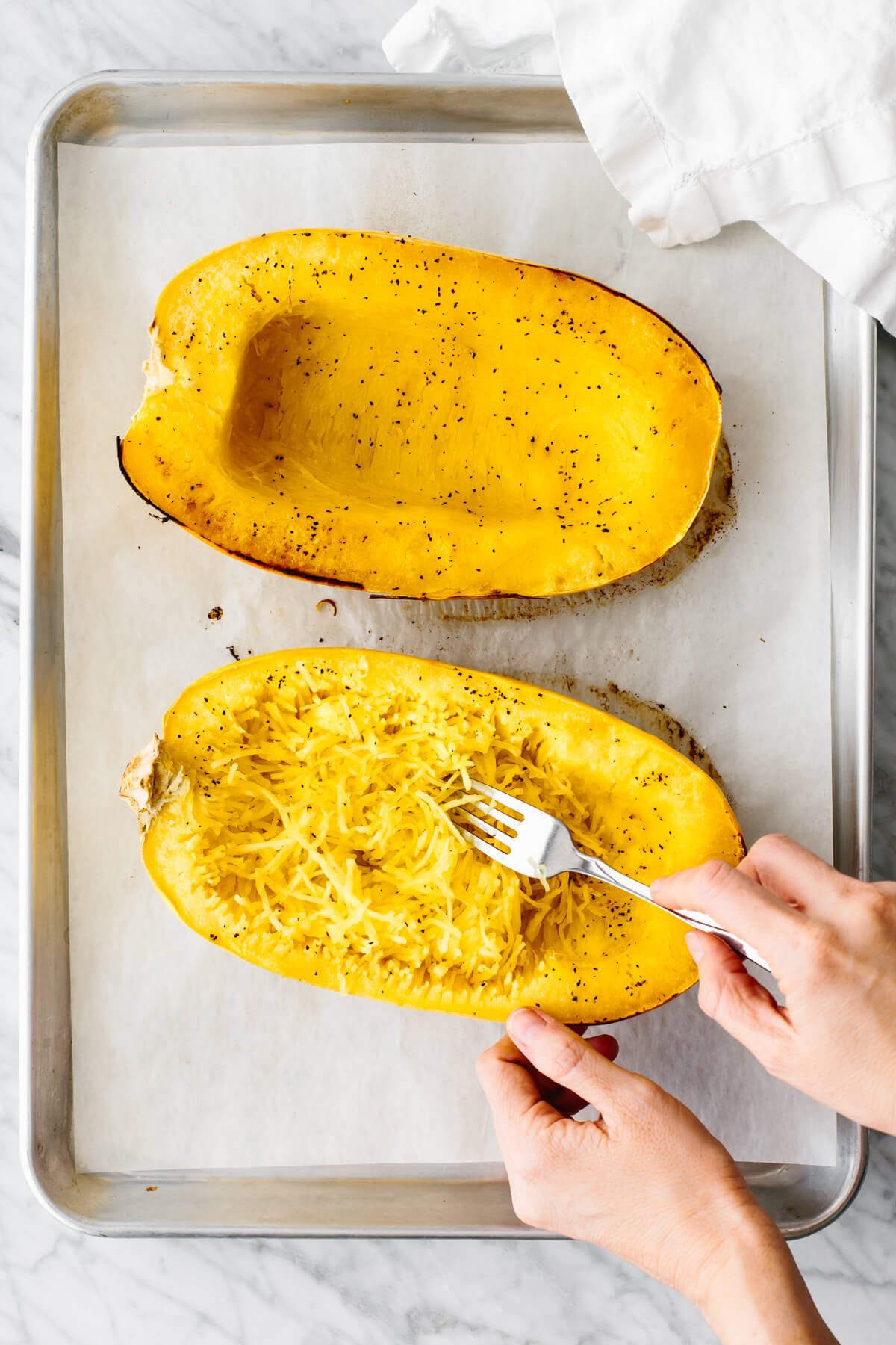 Scraping the inside of a spaghetti squash.