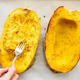 Scraping the inside of a spaghetti squash.