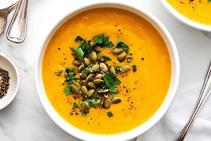 A bowl of butternut squash soup and pepitas.
