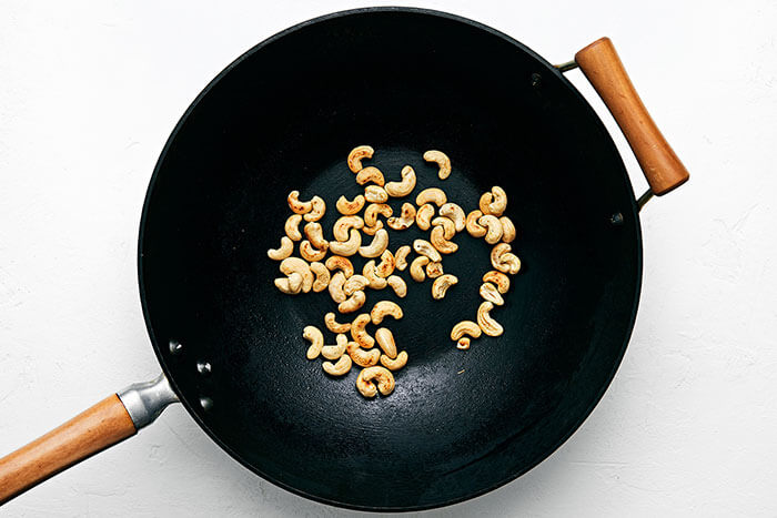 A wok with toasted cashews
