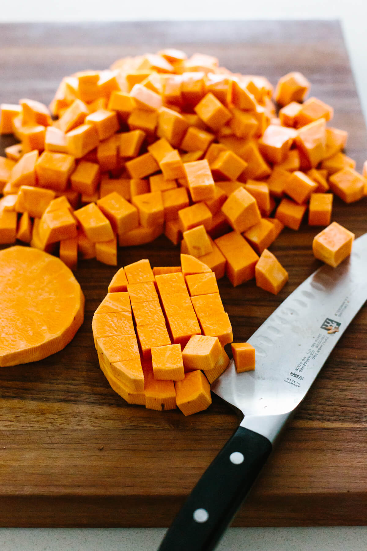 Dicing sweet potatoes into small cubes.