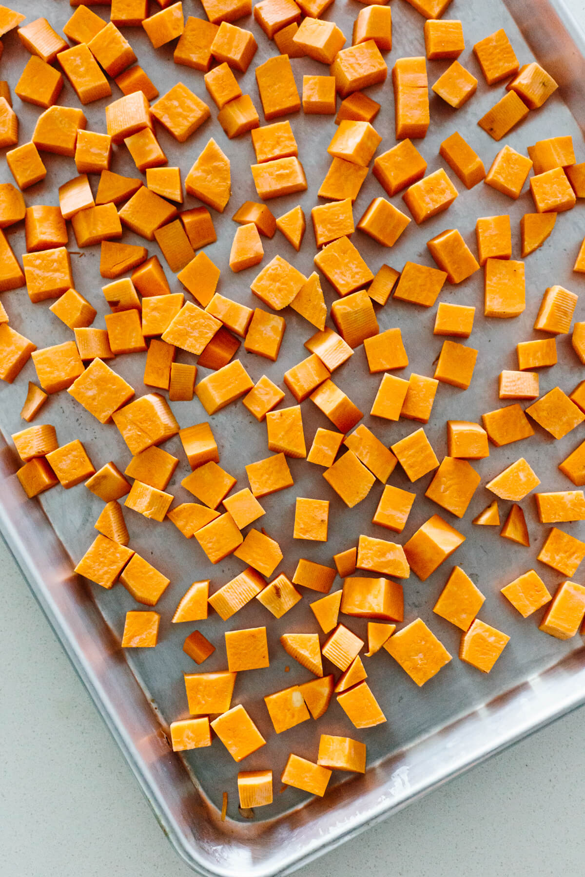 Diced sweet potato on a sheet pan.