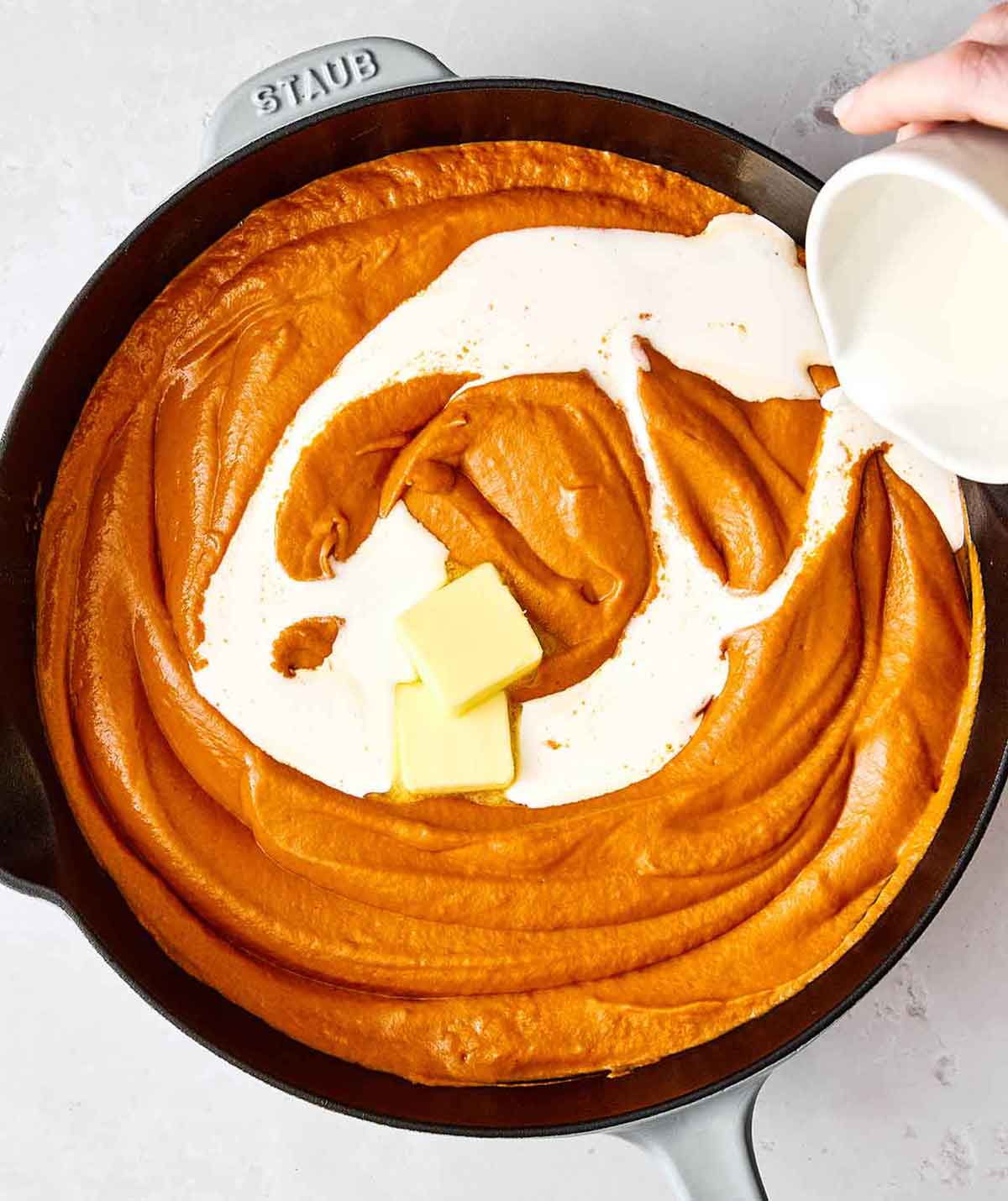 Step five: Adding heavy cream into the butter chicken sauce.