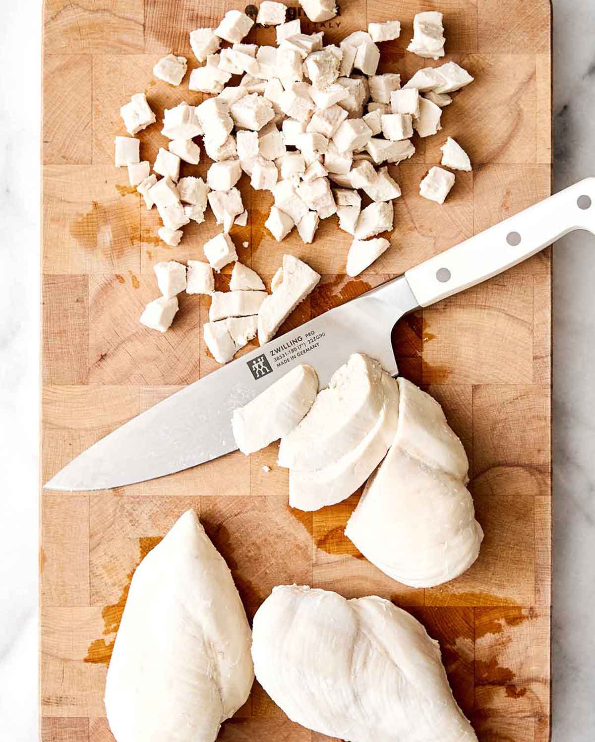 This is everyone's favorite chicken salad! It's layered with fresh flavors, delicious textures, and is sure to be a potluck winner. Step three of chicken salad: dice chicken.