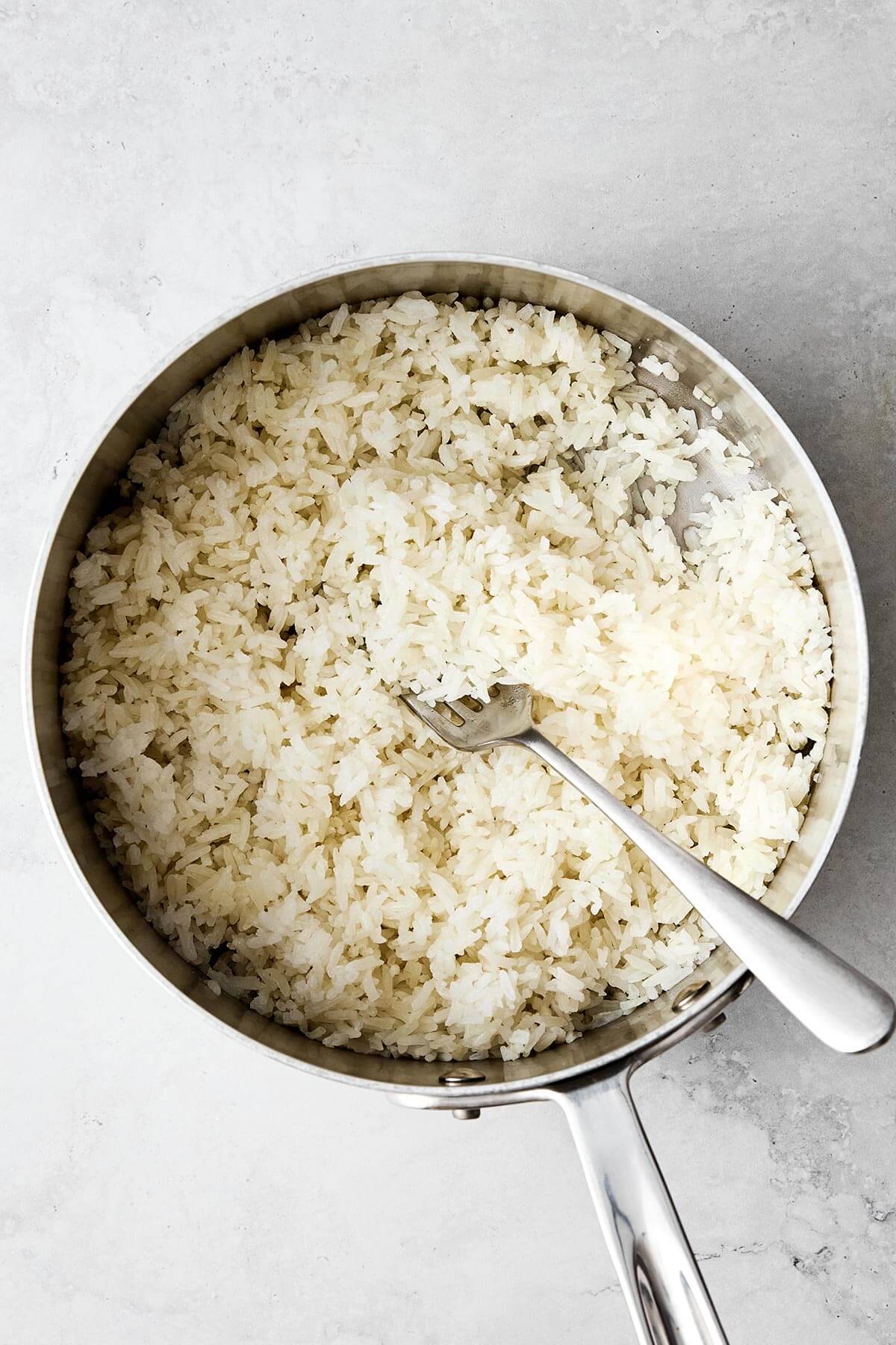 This cilantro lime rice is the best Chipotle copycat! It's bright, and zesty, and is the perfect side dish paired with Mexican mains. Cooked white rice in a pot.