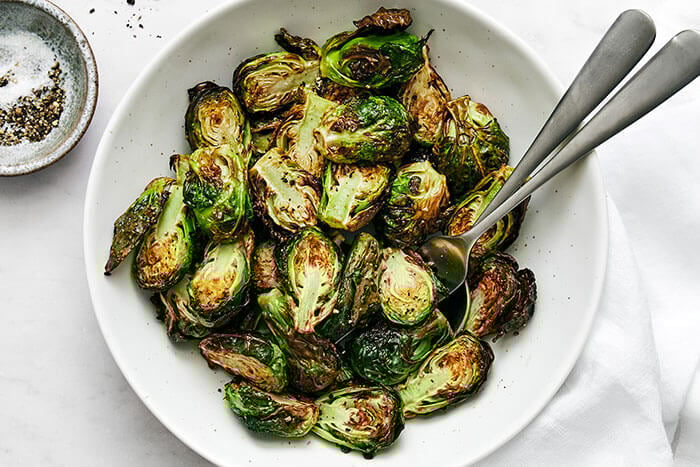 A white bowl of air fryer Brussels sprouts