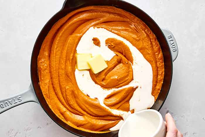 Step five: Adding heavy cream into the butter chicken sauce.