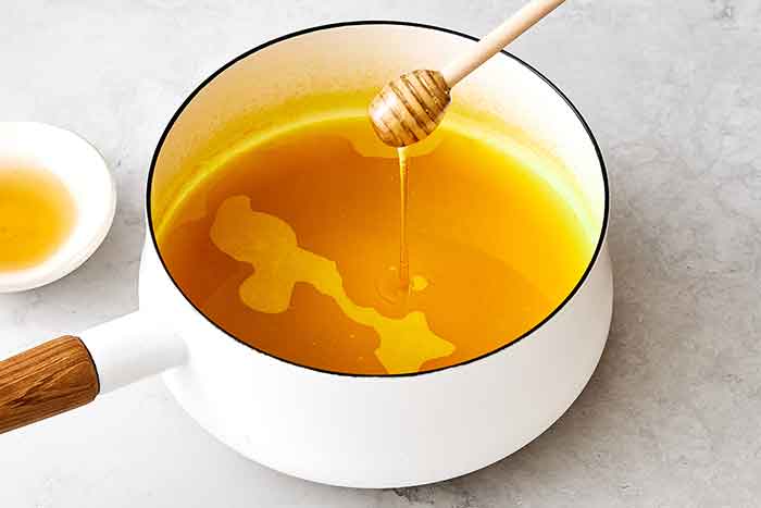 Adding honey to turmeric tea for a little sweetness.