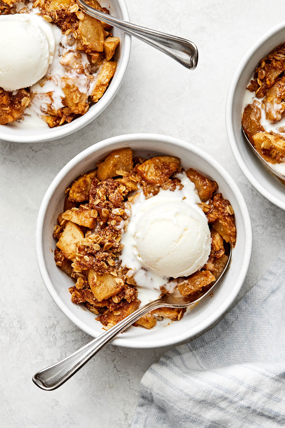 Bowls of apple crisp with ice cream.