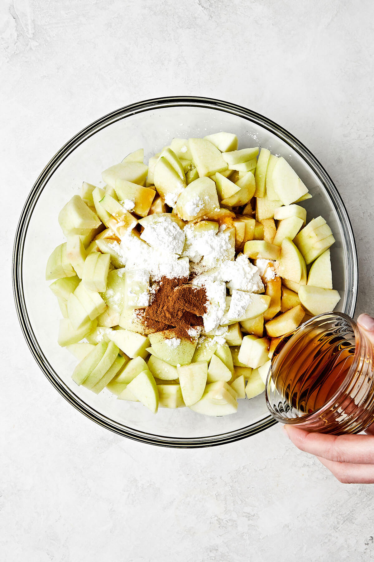 Mixing apples with a sweet cinnamon glaze.