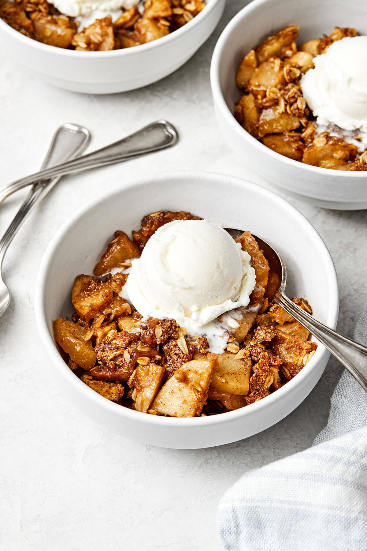 A bowl of apple crisp with ice cream.